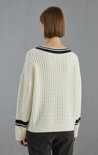 White sequined cable-knit wool sweater back view with black striped hem and cuffs