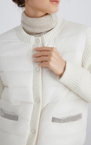 White down puffer jacket close-up: snap placket, ribbed trim, flap pockets