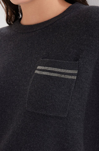 Close-up of black wool knit sweater chest pocket with dual horizontal stripe detail