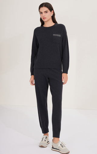 Black wool knit sweater worn with matching pants; chest pocket with stripe detail
