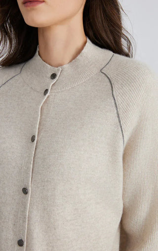 Beige knit cardigan close-up of rounded neckline and dark buttons