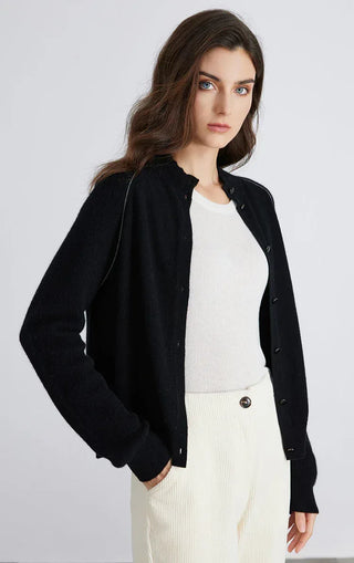 Black knit cardigan worn open, showing button placket and long sleeves
