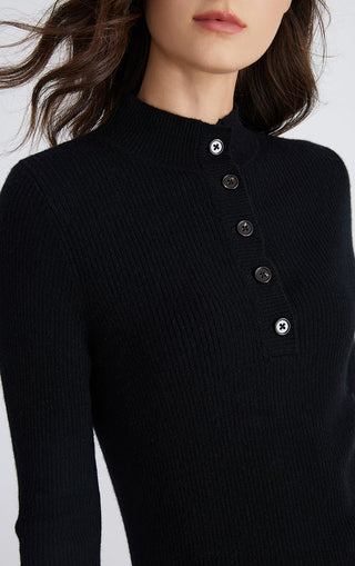 Black mock neck sweater close-up: ribbed knit texture and round front button placket