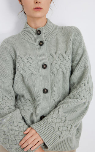 Close-up of matcha green cable-knit cardigan with button front and chunky cable pattern