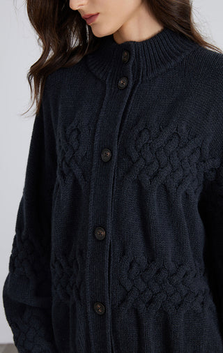 Close-up of dark blue wool cable-knit cardigan with dark buttons and stand collar