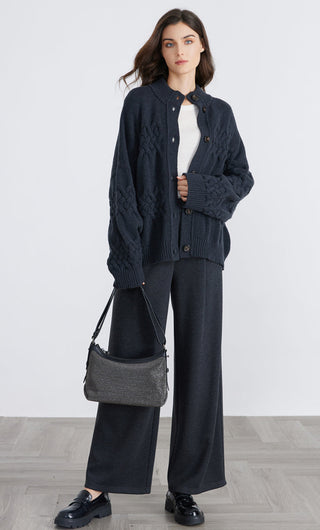 Dark blue button cardigan worn with open front, ribbed hem and cuffs, cable pattern