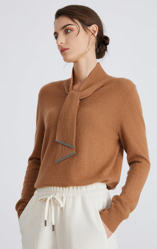 Brown cashmere pullover with tie neck detail, long sleeves, and hip pocket