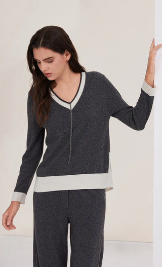 Graphite gray cashmere knit top with V-neck trim and white hem band at waist