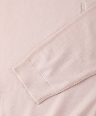 Light apricot crewneck sweater sleeve cuff and hem knit close-up