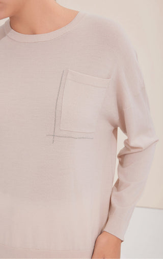 Light apricot knit crewneck close-up, pocket and silver bead line on front