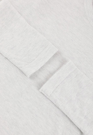 Close-up of light heather knit fabric on sheer long-sleeve scoop-neck top.