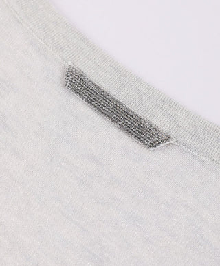 Close-up of sparkly back-neck strap detail on the sheer scoop-neck knit top.