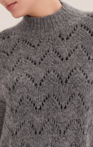 Gray-blue openwork knit close-up with diamond pattern and scattered sequins