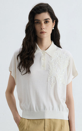 White wool-silk polo knit top with short sleeves, button placket, and sequin embellishment