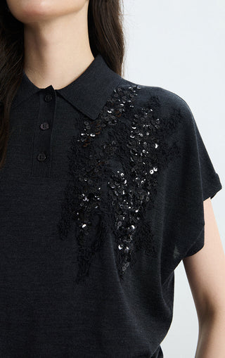 Black polo knit top with button placket and dense right-chest sequin cluster detail
