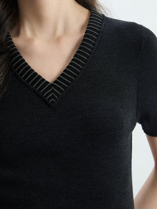 Close-up of black V-neck ribbed knit top with striped knit trim
