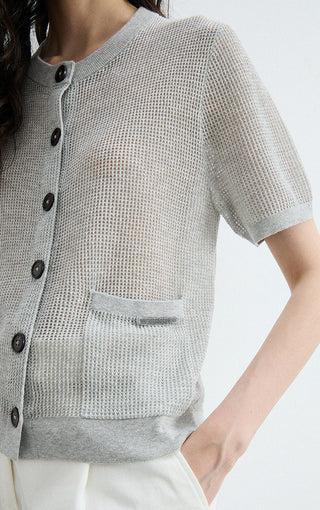 Gray sheer knit cardigan close-up: textured fabric, dark buttons, chest pocket detail