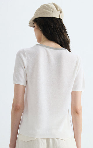 Back view of ivory knit top with silver-trim crew neckline
