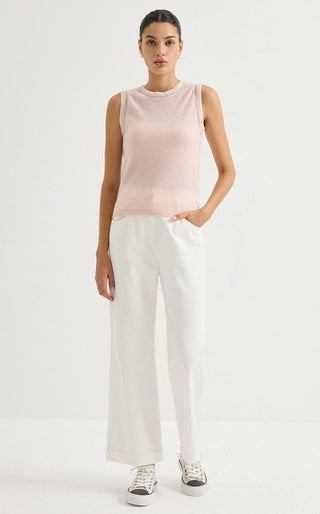 Light pink sleeveless knit top with contrast trim, styled with light wide-leg pants