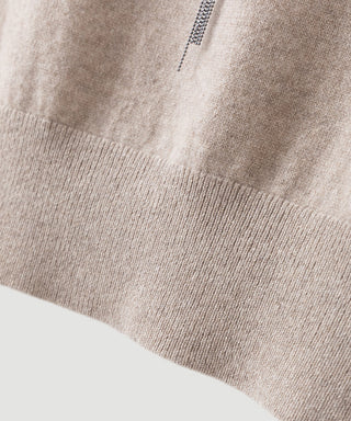 Close-up of khaki cashmere knit hem with ribbed edge and small placket detail