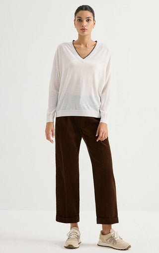 White wool fine-knit V-neck sweater styled with dark trousers, full view
