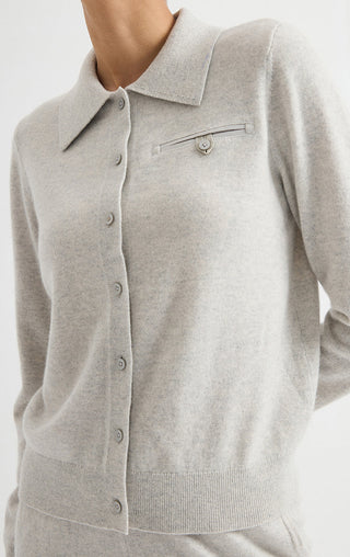 Light grey collared cardigan close-up with button placket and chest logo detail