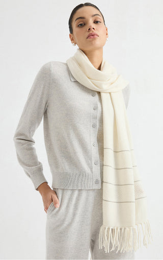 Ivory cashmere openwork wrap with striped knit panels and fringe ends, draped over shoulders