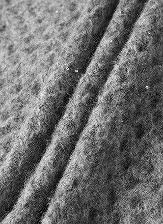 Gray openwork knit fabric close-up with fuzzy texture and dotted holes