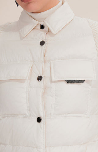 Close-up of white down shirt jacket: spread collar, snap buttons, and chest patch pockets