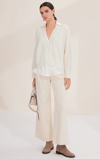 White cardigan draped over silk vest, V-neck and ruffle hem, full-length view