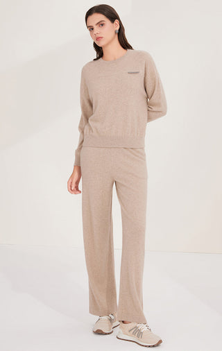 Camel cashmere knit top with crew neckline, long sleeves, and small shimmer accent tab detail.