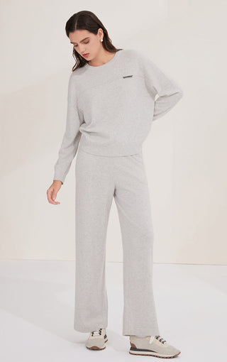 Light gray cashmere knit top with crew neckline, long sleeves, and small chest shimmer accent tab.