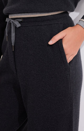 Dark gray knit pants close-up: drawstring waist and ribbed waistband