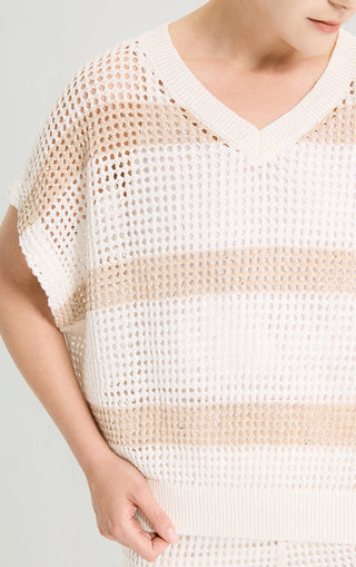 Close-up of white open-knit V-neck top with tan sequined stripe detail