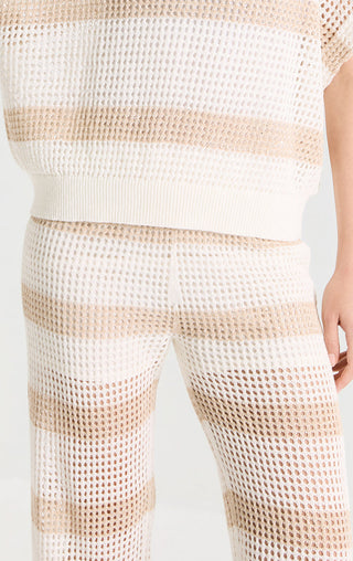 Close-up of beige open-knit stripe pants with textured knit pattern and seams