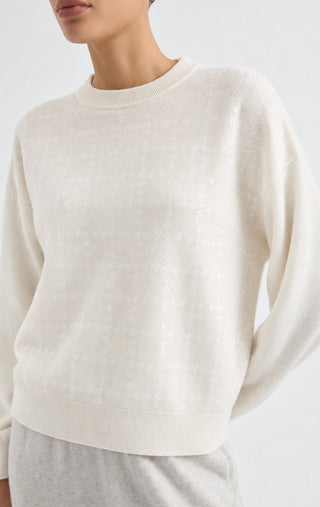 Close-up of white cashmere crewneck sweater with fine sequin texture