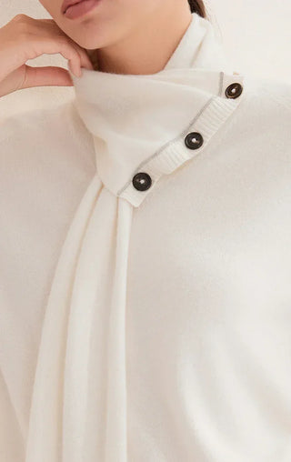 White knit sweater close-up of scarf neck with three dark buttons and seam detailing