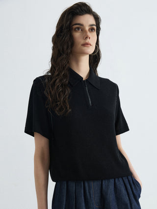 Black half-zip polo knit top with high ribbed neckline and short sleeves
