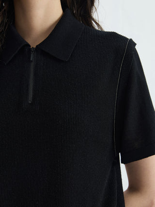 Close-up: black half-zip polo knit top with ribbed texture and visible zipper detail