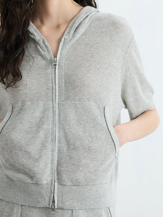 Gray ribbed hooded zip-up top close-up: front zip, patch pockets, drawstring hood.