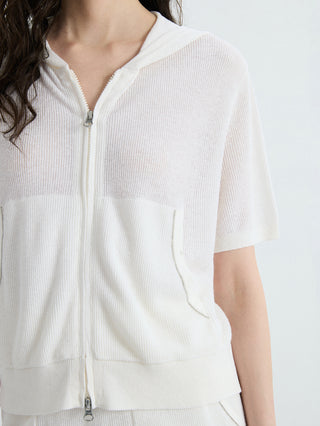 Ivory ribbed hooded zip-up top close-up: front zip, drawstring hood, patch pocket.