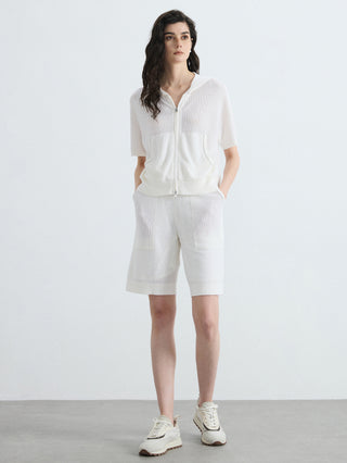 Ivory hooded zip-up ribbed top with front zip, kangaroo pockets, and short sleeves.