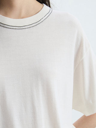 Close-up of white cropped knit T-shirt neckline with contrast ribbed crew trim