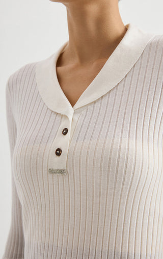White ribbed polo sweater close-up, V-neck collar with buttons and small chest tag