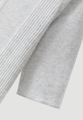 Close-up of light grey ribbed knit sweater sleeve and side hem