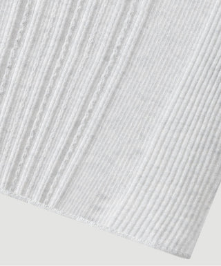 Close-up of light grey ribbed knit fabric with mock-neck sweater hem