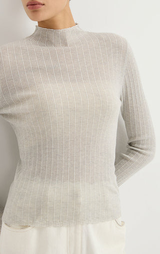 Light gray ribbed knit turtleneck sweater close-up, long sleeves with neat cuffs