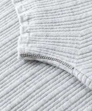 Ribbed mock-neck sweater detail with silver-toned button trim, light gray