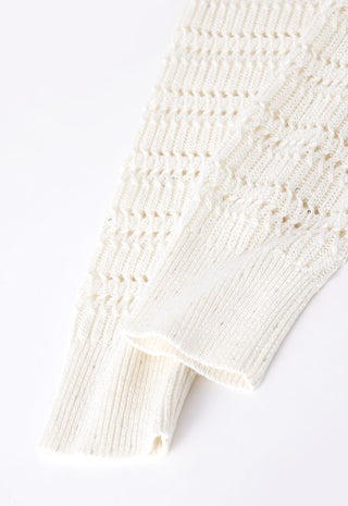 Ivory open-knit cardigan sleeve and hem detail with fringe thread accents