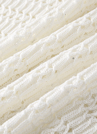 Ivory open-knit fabric close-up with tiny sequin yarn dots across stitches